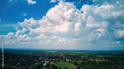 Aerial drone hyper lapse time lapse of beautiful Green farming community and a factory on a beautiful cloudy day.