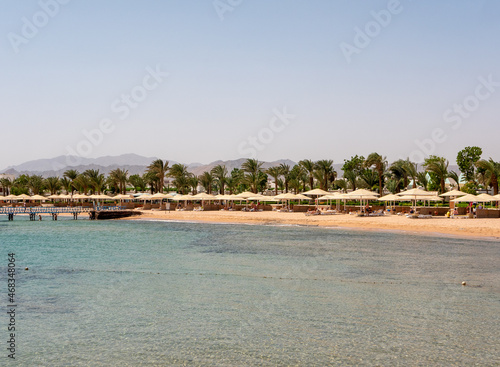 Hurghada, Egypt - September 22, 2021: View of the Red Sea coast. People are relaxing and swimming on the sandy beach. Copy space.