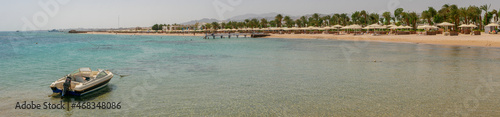 Hurghada, Egypt - September 22, 2021: Panoramic view from the motor boat and the coast of the red sea. People are relaxing and swimming on the sandy beach.