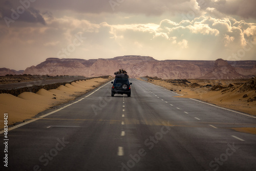 The car drives along the road leading through the Black and White Desert in Bahariya. Egypt