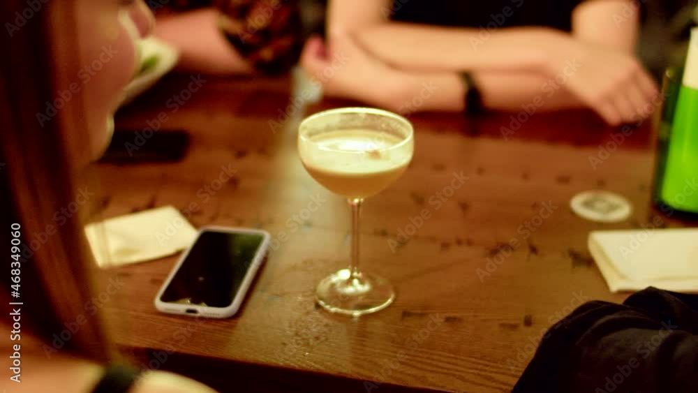 Raise a glass and cheers to good company and delicious cocktails as a group of friends enjoy a night out in a bar, captured in a close-up view and stunning 4K video Raise a glass and cheers to good company and delicious cocktails as a group of friends enjoy a night out in a bar, captured in a close-up view and stunning 4K video