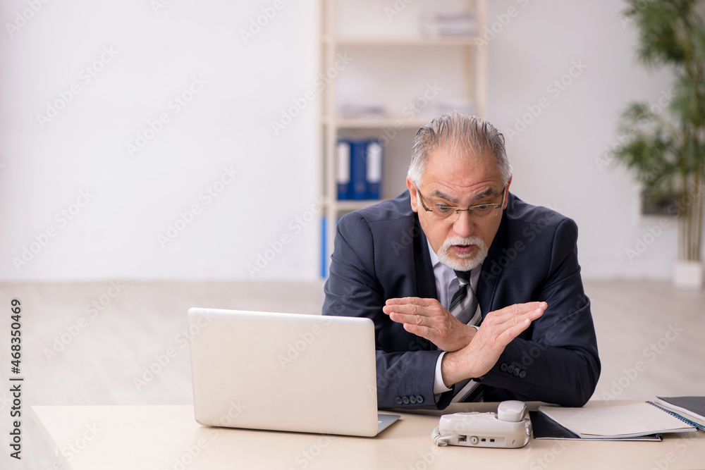 Old male employee working in the office Old male employee working in the office