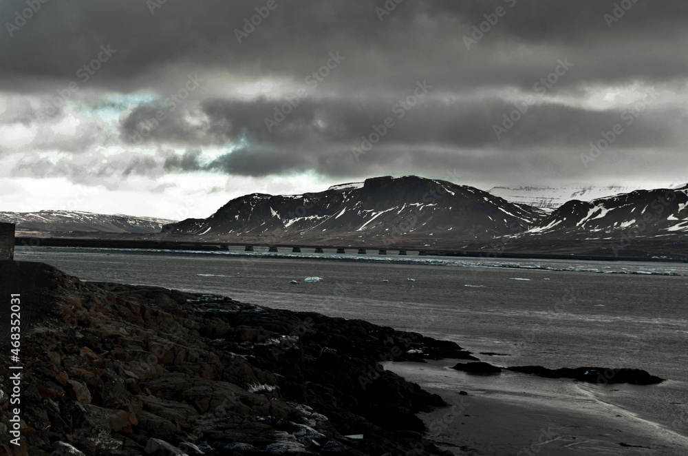 Akranes, iceland snow-capped mountain peaks and blue waters of the bay