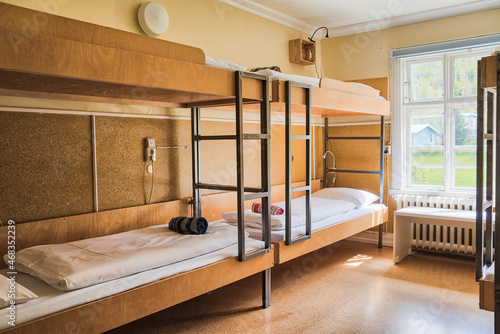 Cosy and quiet room with bunk beds and walls covered with warm colours and ecological environment and recycled materials.Family room. Shared hostel room. Nordic atmosphere and decoration. photo