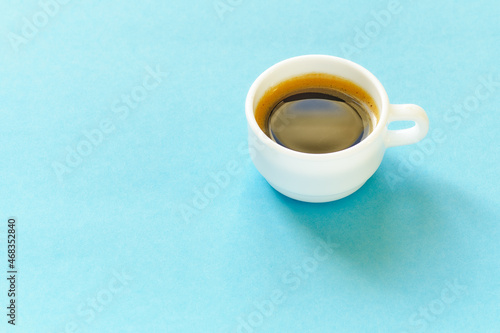 White coffee cup on blue background with free space for text