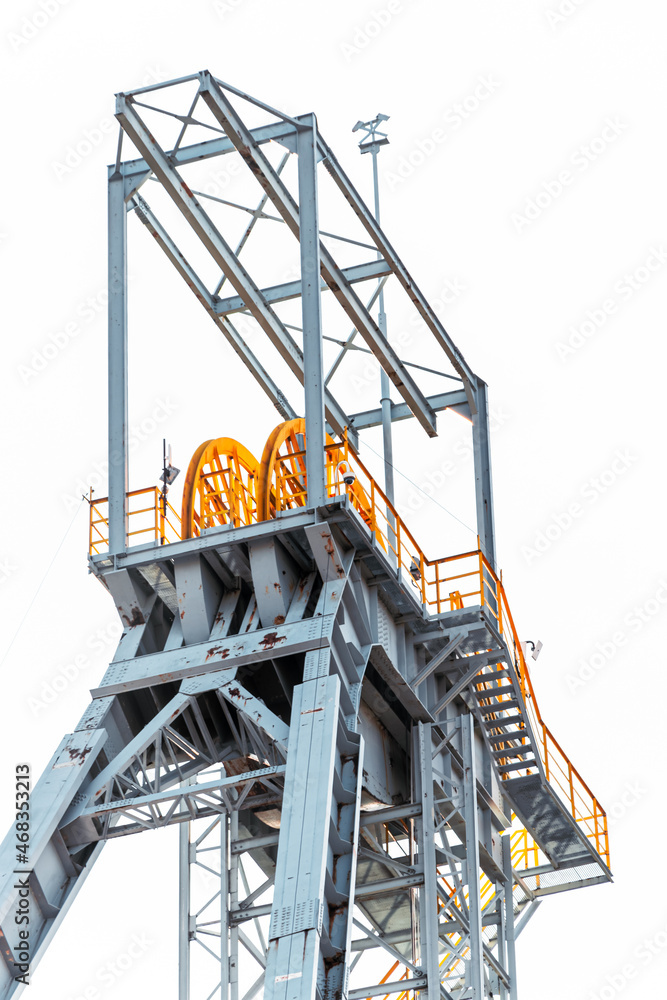 Mine shaft tower 'Krystyn' in former coal mine 'Michal' in Siemianowice, Silesia, Poland seen from below against blue sky.