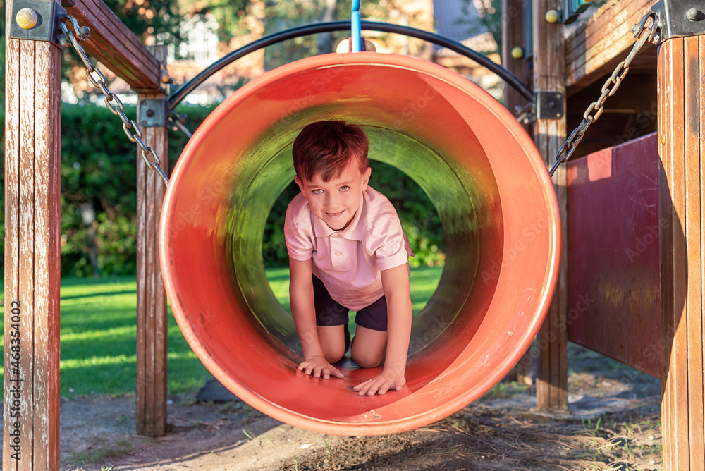 Green-eyed boy smiling while playing in a playground Green-eyed boy smiling while playing in a playground