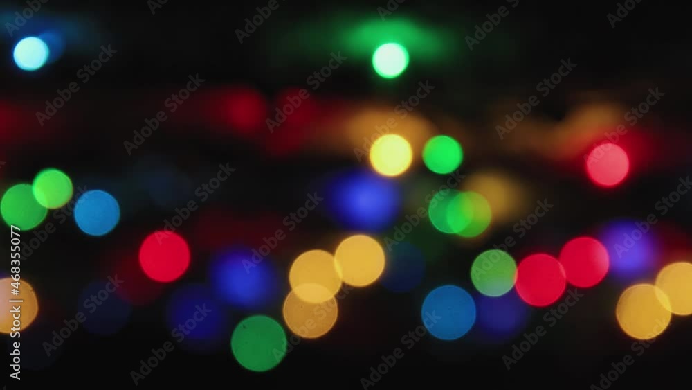 Multi-colored lights on a black background flicker smoothly, copy space. Greeting card for Christmas, New Year, Birthday. Festive video for intro, transition, splash screen. Copy space. UHD 4K. Multi-colored lights on a black background flicker smoothly, copy space. Greeting card for Christmas, New Year, Birthday. Festive video for intro, transition, splash screen. Copy space. UHD 4K.