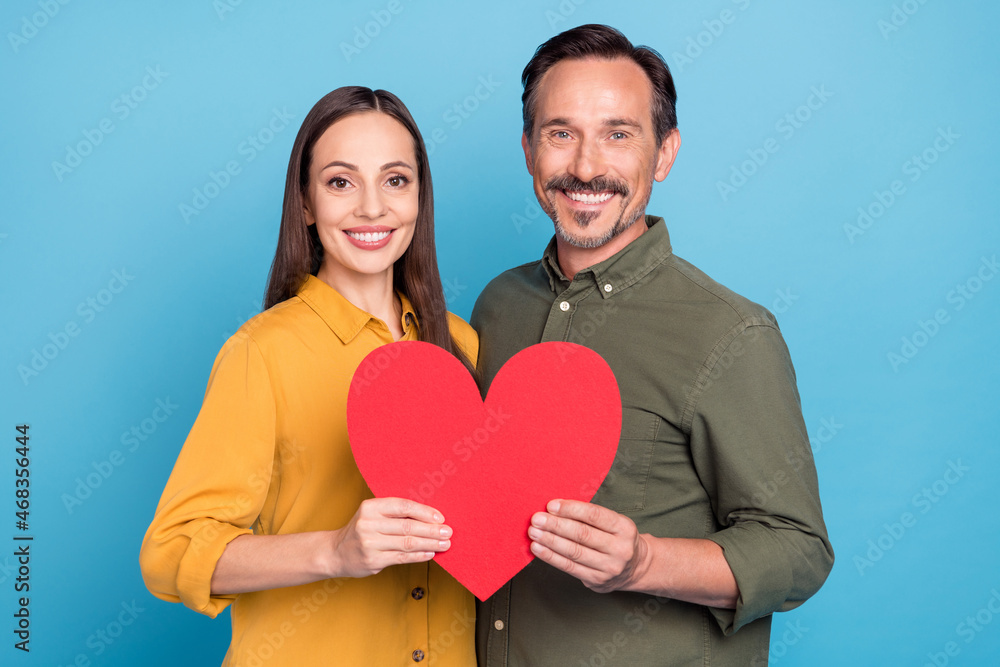 Photo of pretty lady handsome guy hold large heart symbol toothy smile isolated on blue color background