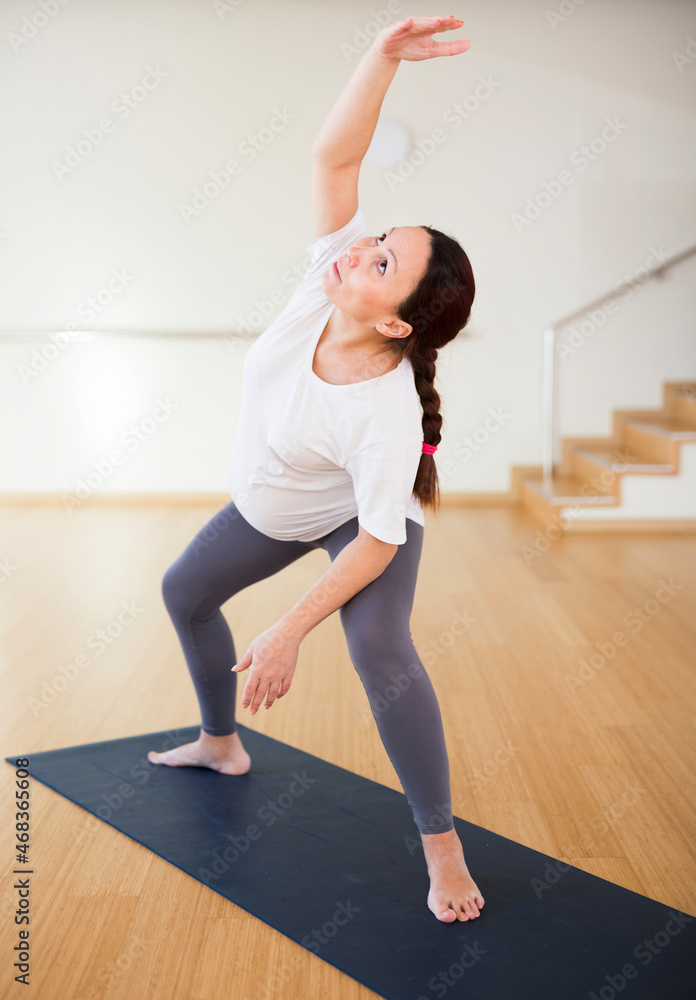Fototapeta premium Pregnant woman is engaged in yoga. Extended Side Angle Pose or Utthita Parsvakonasana