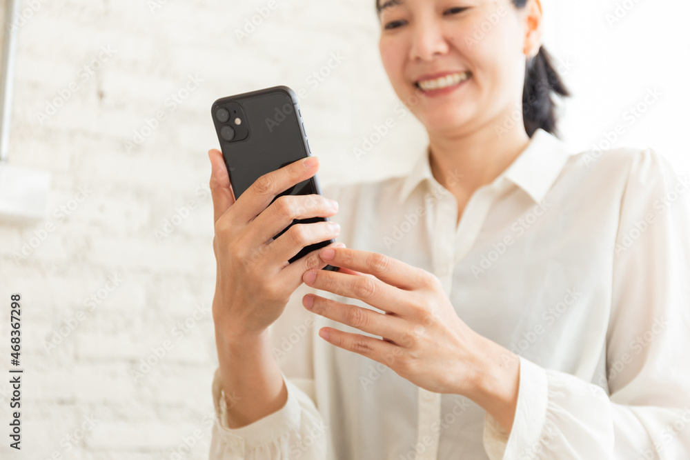 using cell phone hand holding mobile texting message contact us.chatting,search internet information in office.technology device communication connecting