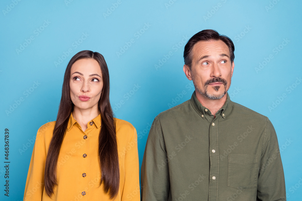 Photo of mature minded married man and woman look empty space idea isolated on pastel blue color background Photo of mature minded married man and woman look empty space idea isolated on pastel blue color background