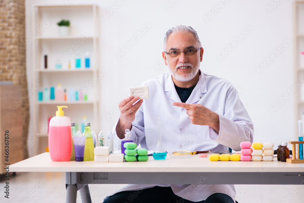 Old male chemist testing soap in the lab Old male chemist testing soap in the lab