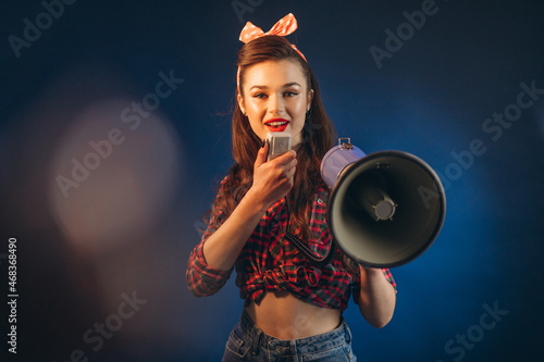 Young woman pinup style standing with loud speaker