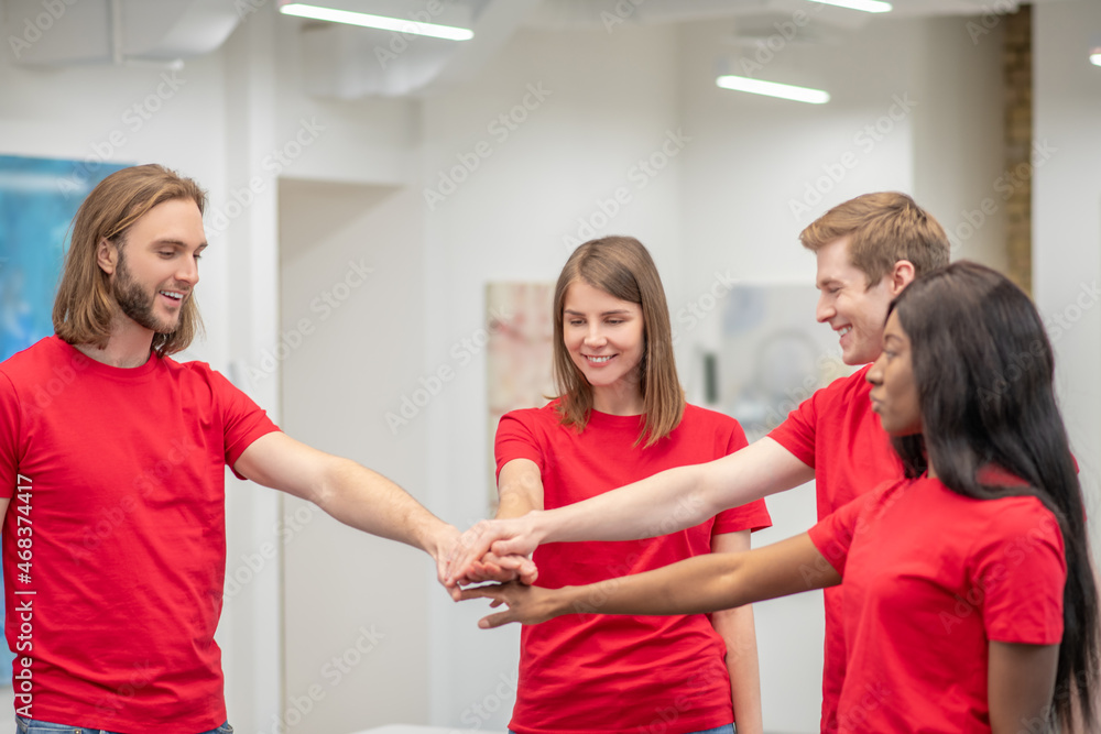 Obraz premium Team of young volunteers in red tshirt