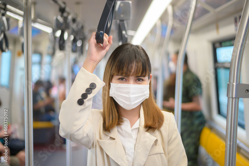 Young woman is wearing protective mask in metro , covid-19 protection , safety travel , new normal , social distancing , safety transportation , travel under pandemic concept