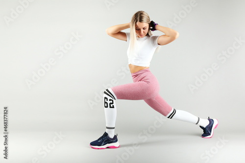 athlete woman is doing sports exercise lunges on white background studio shot. 
