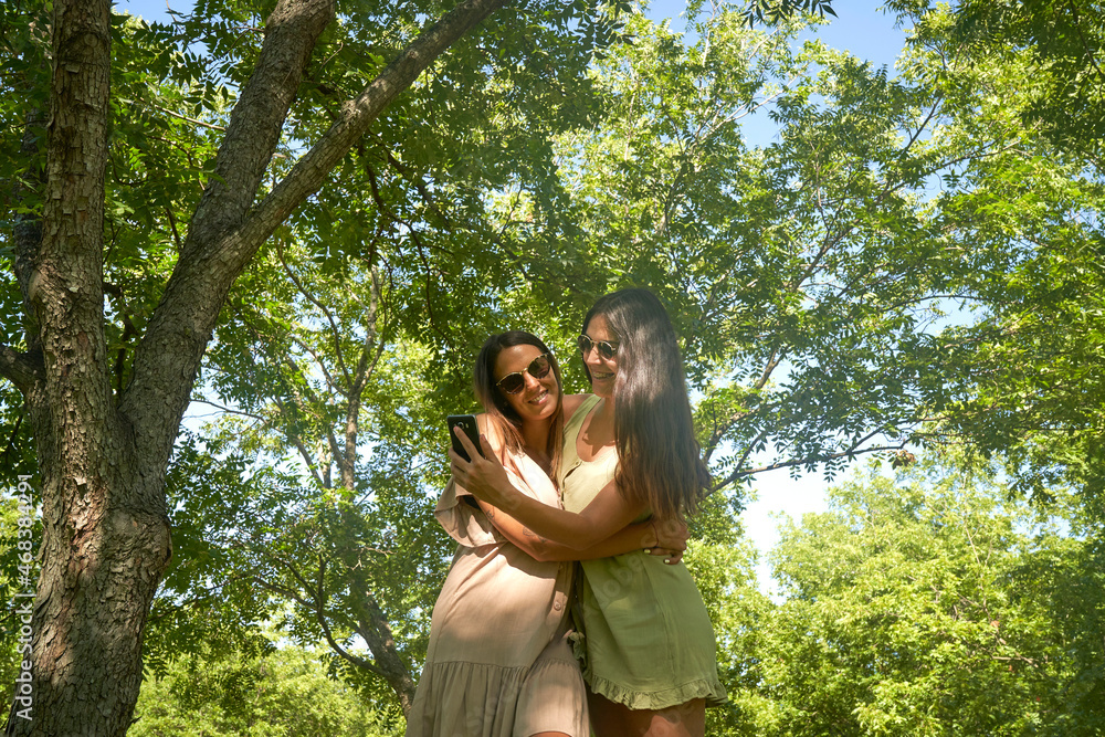 Happy lesbian couple lying together on grass at park Happy lesbian couple lying together on grass at park