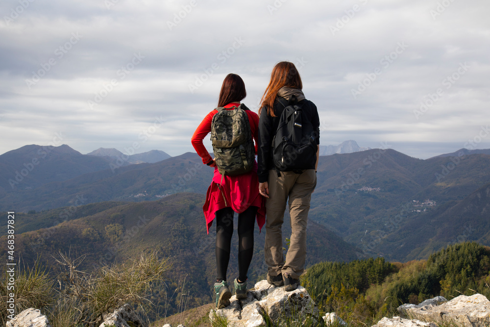 Two middle aged women on top of a mountain in autumn