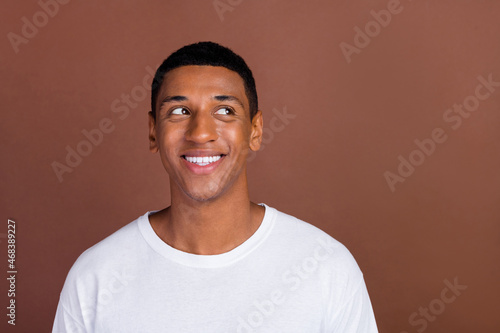 Photo of young handsome african man wondered thoughtful look empty space isolated over brown color background