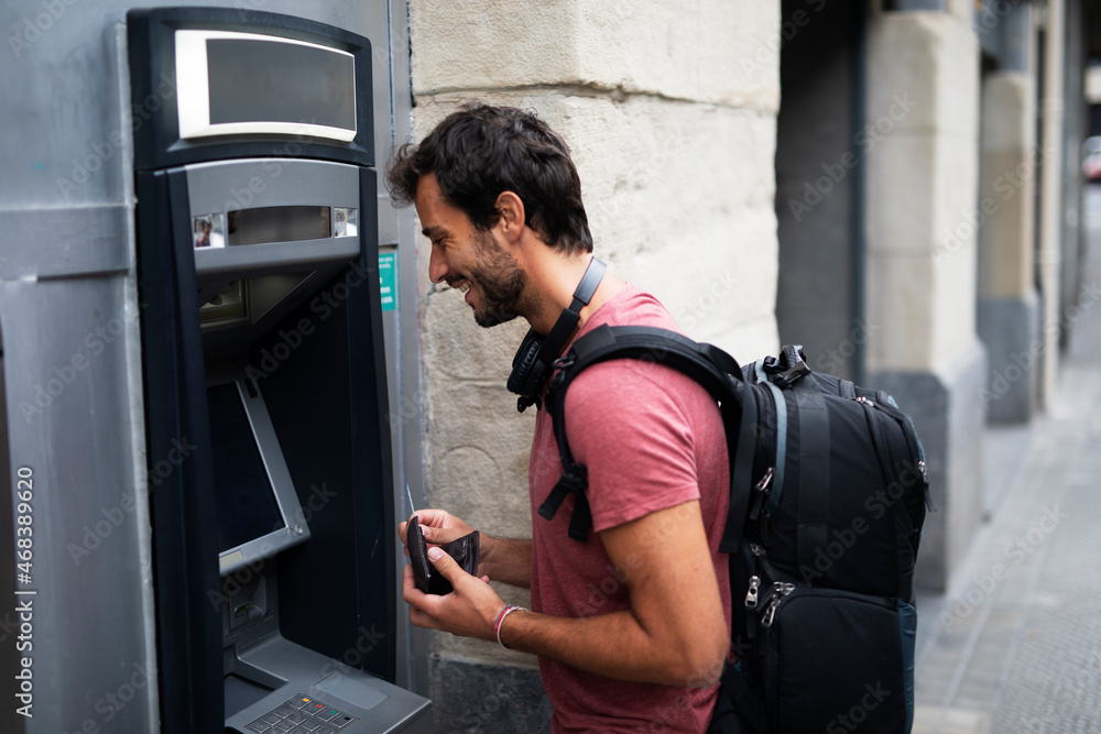 Young man withdrawing money from credit card. Man typing pin code on keypad of ATM mashine. Young man withdrawing money from credit card. Man typing pin code on keypad of ATM mashine.