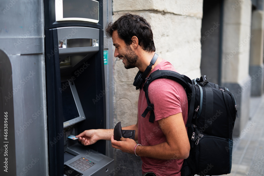 Young man withdrawing money from credit card. Man typing pin code on keypad of ATM mashine. Young man withdrawing money from credit card. Man typing pin code on keypad of ATM mashine.