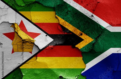 flags of Zimbabwe and South Africa painted on cracked wall photo