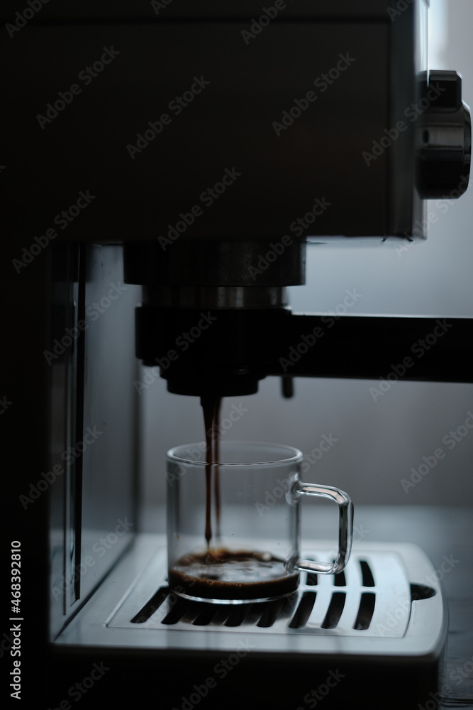Coffee drips from the holder into a transparent glass mug Coffee drips from the holder into a transparent glass mug