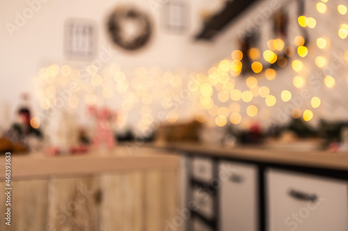 Cozy flat kitchen room green Christmas Tree gifts presents garlands, decorated toys balls interior New Year beautiful living room in the evening, lights glowing bokeh background