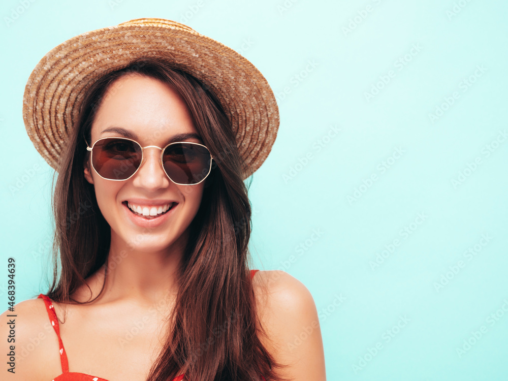 Closeup portrait of young beautiful smiling female in trendy summer dress.Sexy carefree woman posing near blue wall in studio.Positive model having fun indoors.Cheerful and happy in sunglasses and hat Closeup portrait of young beautiful smiling female in trendy summer dress.Sexy carefree woman posing near blue wall in studio.Positive model having fun indoors.Cheerful and happy in sunglasses and hat