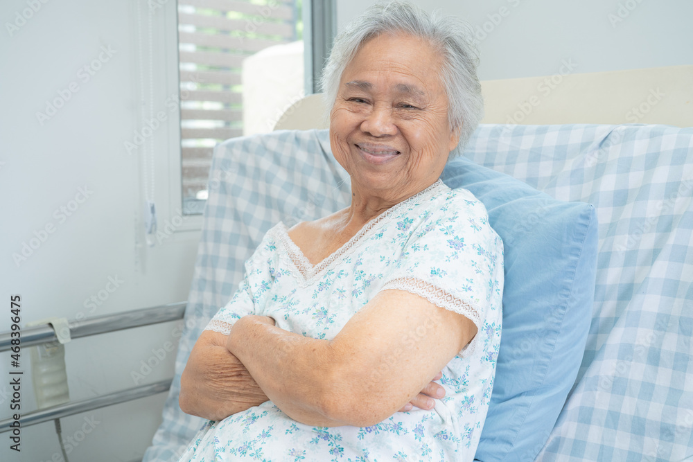 Asian senior or elderly old lady woman patient smile bright face while sitting on bed in nursing hospital ward, healthy strong medical concept. Asian senior or elderly old lady woman patient smile bright face while sitting on bed in nursing hospital ward, healthy strong medical concept.