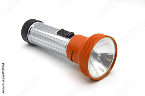 Vintage metal orange flashlight torch isolated on a white background