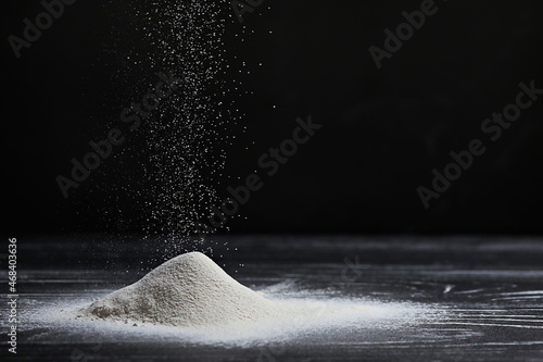 Flour is poureing on the table. photo