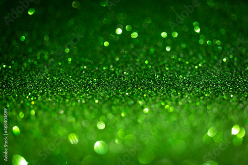 Dark green glitter lights. Shiny sparkles, bokeh effects, glowing surface. Selective focus, christmas abstract background