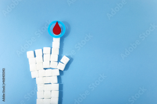 World diabetes day awareness. Blue circle with blood drop and hand shaped sugar cubes. photo