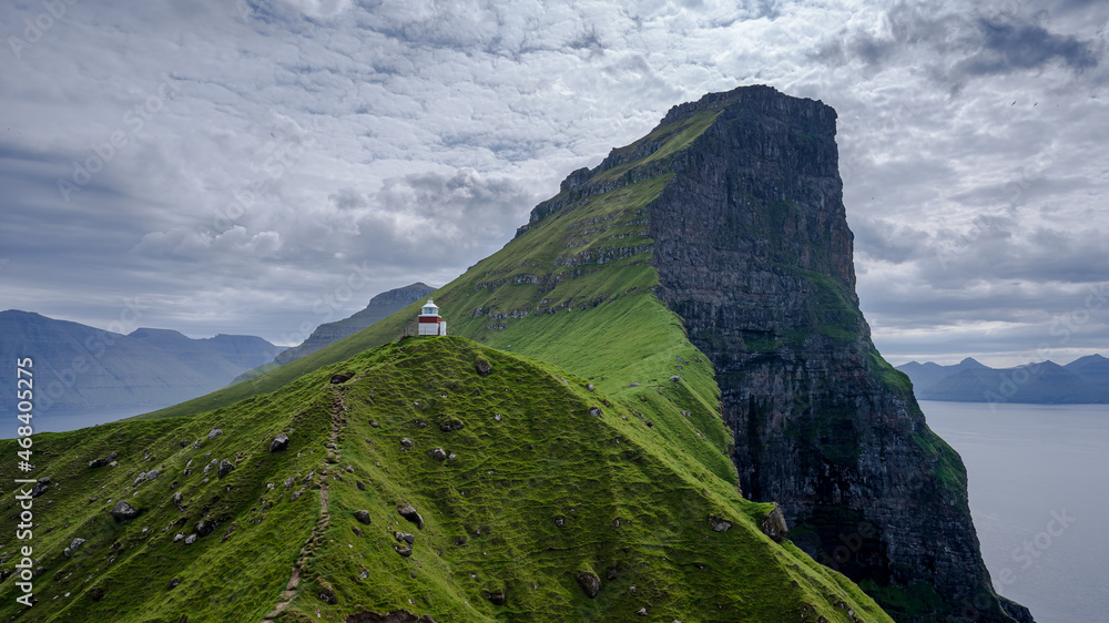 Beautiful aerial view of the Kallur Lighthouse in the Faroe Islands, and its massive cliffs, crags hikes and ocean views