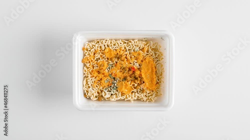 Chinese instant noodles animation video. Stop motion food. Top view box with noodles on white table, brewing with boiling water and leaving frame photo