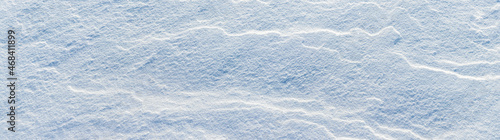 Snow texture with wavy solid surface in sunny weather, winter background