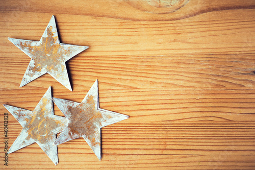 Craft paper stars on wooden background, copy space, frame. Christmas frame with handmade paper stars