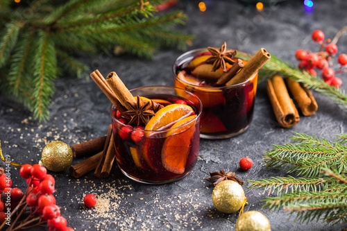 Glass mugs of mulled wine with spices and citrus fruits. Traditional hot drink or beverage, festive cocktail at X-mas or New Year photo