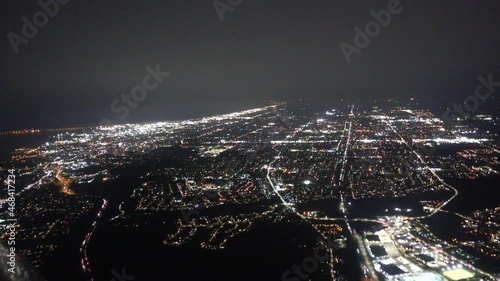 Airplane Aerial At Night Flying Over Major City With Heavy Fog Towards Lake Water photo