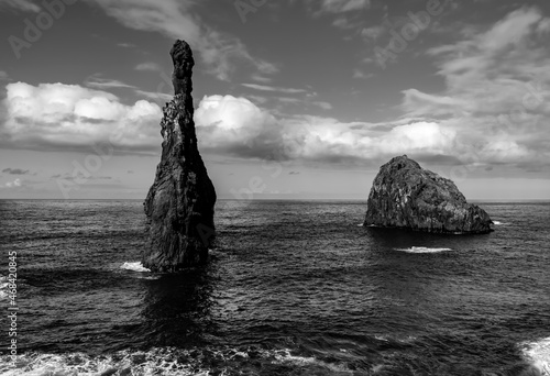 “Mirador Ilheus da Ribeira da Janela“ is a rocky beach on the north coast of Madeira island Portugal near Porto Moniz. Formation of 3 high rocks with characteristic shape, black and white greyscale.