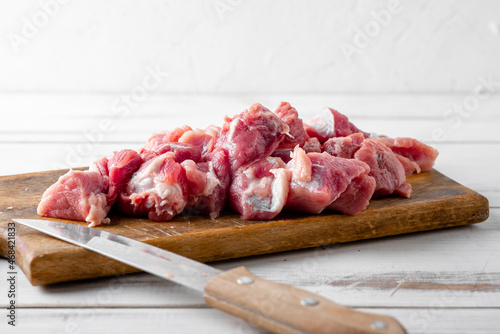 Sliced pieces of raw meat on a cutting board. Pork or beef is prepared for cooking.
