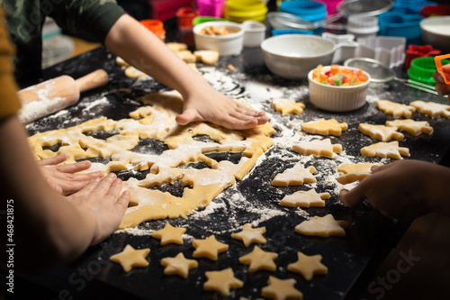 Children cook New Year's cookies together. Carving Christmas trees and stars out of dough. Preparation for the holiday. Homemade sweets.