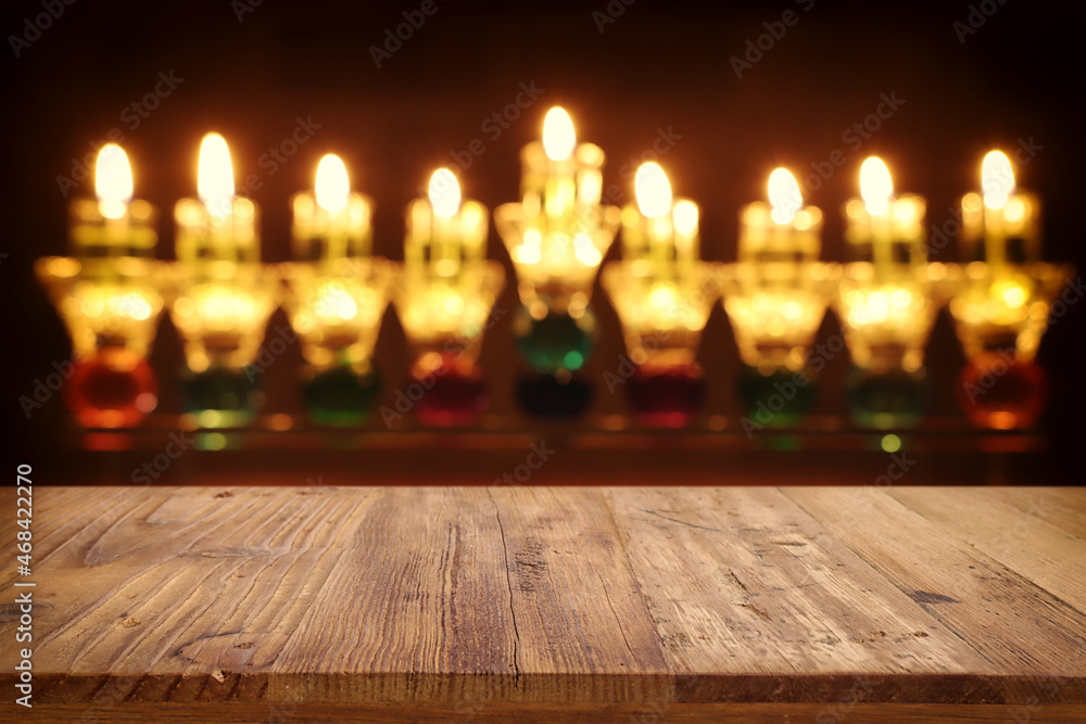 religion image of empty wooden table in front of jewish holiday Hanukkah background with menorah (traditional candelabra). For product display religion image of empty wooden table in front of jewish holiday Hanukkah background with menorah (traditional candelabra). For product display