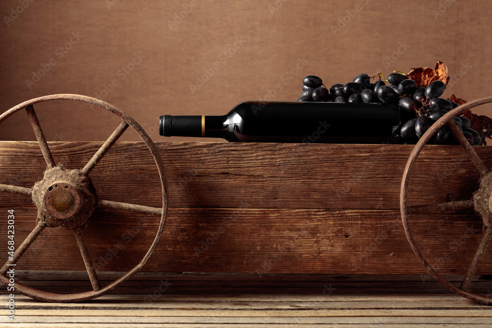 Old wooden cart with bottle of red wine and grapes. Old wooden cart with bottle of red wine and grapes.