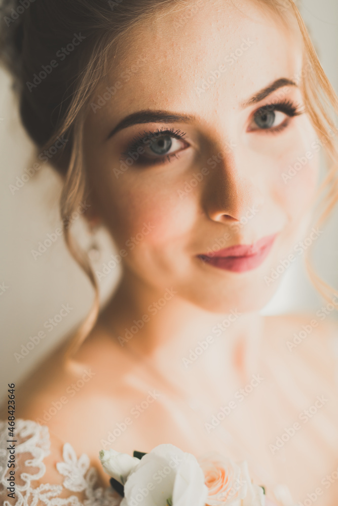 Gorgeous bride in robe posing and preparing for the wedding ceremony face in a room Gorgeous bride in robe posing and preparing for the wedding ceremony face in a room