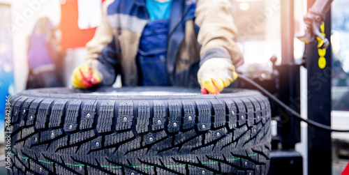 Quadro su tela Master mechanic inflates wheel with air at tire fitting station banner photo