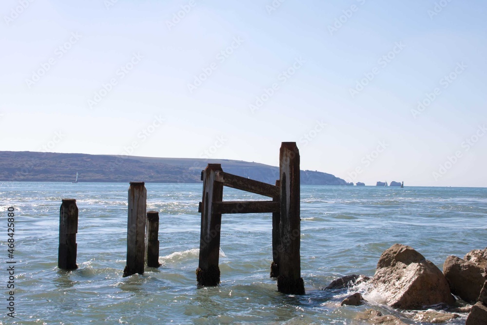 Fototapeta premium old wooden groynes in the sea with The Isle of Wight and The Needles in the background