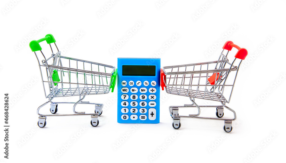 Electronic calculator and two grocery carts on white background. Concept of sales and purchases in stores. Discounts and savings. Iron miniature supermarket trolley hold electronic computing machine. Electronic calculator and two grocery carts on white background. Concept of sales and purchases in stores. Discounts and savings. Iron miniature supermarket trolley hold electronic computing machine.